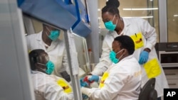 Melva Mlambo, à droite, et Puseletso Lesofi, deux scientifiques médicaux se préparent à séquencer des échantillons d'omicron COVID-19 au Centre de recherche Ndlovu à Elandsdoorn, Afrique du Sud, le 8 décembre 2021.