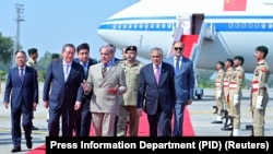 巴基斯坦总理夏巴兹·谢里夫（中）在机场欢迎中国总理李强抵达伊斯兰堡。（2024年10月14日）