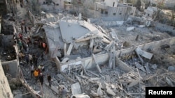 이스라엘 군의 공격으로 파괴된 가자지구 남부 칸 유니스의 주택가를 팔레스타인 거주민들이 둘러보고 있다.