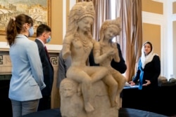 Afghan Ambassador to the U.S. Roya Rahmani, right, accompanied by embassy staff, speaks as she gives the Associated Press a tour at the Afghanistan Embassy in Washington, Wednesday, April 21, 2021