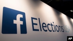 In this Aug. 6, 2015, file photo Facebook Elections signs stand in the media area in Cleveland before the first Republican presidential debate. (AP Photo/John Minchillo)