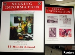 FBI posters displaying works by artists Johannes Vermeer and Edgar Degas are seen during a press conference held to appeal to the public for help in returning artwork stolen in 1990 from the Isabella Stewart Gardner Museum in Boston, Massachusetts.