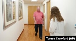 In this July 9, 2019 photo, Dr. Jori Fleisher, neurologist, examines Thomas Doyle, 66, at the Rush University Medical Center in Chicago. Doyle, 66, hopes blood tests may someday replace the invasive diagnostic testing he endured to be diagnosed 4.5 years