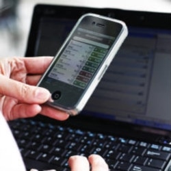 An amateur trader, Yan Qin, checks her smartphone for stock reports in New York on December 7