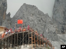 This Sept. 22, 2018 photo shows tourists visiting the Baishui Glacier No.1 atop of the Jade Dragon Snow Mountain in the southern province of Yunnan in China home. Scientists say the glacier is one of the fastest melting glaciers in the world due to climate change and its relative proximity to the Equator. It has lost 60 percent of its mass and shrunk 250 meters since 1982. (AP Photo/Sam McNeil)