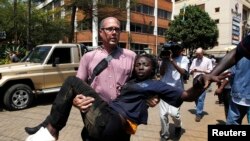 Un journaliste portant une femme blessée