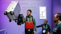 Eric Lynn lifts a 50 pound suitcase with the help of a powered arm similar to the Sarcos Robotics Guardian XO at the Delta Airlines booth during the CES tech show, Wednesday, Jan. 8, 2020, in Las Vegas.