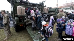 Fighting in Ukraine has affected life there. Here, children wait in line to see a U.S. militiary vehicle during the "Dragoon Ride" military exercise in Prague, March 31, 2015. (FILE PHOTO)