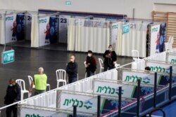 FILE - People queue to receive a vaccine against COVID-19 at a makeshift vaccination site in Petah Tikva, Israel, Jan. 28, 2021.