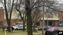 Полицейские машины вокруг школы в Мэдисоне, где произошла стрельба. 16 декабря 2024г.. (AP Photo/Scott Bauer).