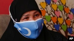 Bumeryem Rozi, 55, an ethnic Uyghur who fled from China to Turkey, cries as she talks to The Associated Press, at her home, in Istanbul, Tuesday, June 1, 2021. (AP Photo/Mehmet Guzel) 