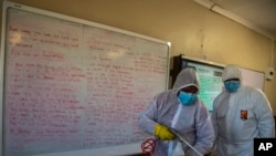 Une équipe désinfecte une salle de classe de l'école secondaire Ivory Park à l'est de Johannesburg, en Afrique du Sud, le 28 mai 2020. (Photo AP)