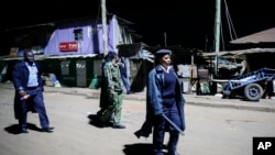 La police kényane portant des matraques et des gaz lacrymogènes patrouille à la recherche de personnes après le couvre-feu dans le bidonville de Kibera à Nairobi, au Kenya, le 29 mars 2020.