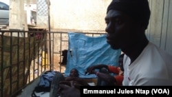 La devanture d’une boutique transformée en habitat à ciel ouvert de quatre jeunes réfugiés centrafricains à Yaoundé. (VOA/Emmanuel Jules Ntap)