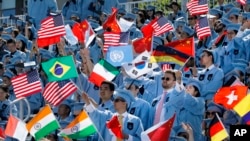 FILE - Columbia University students celebrate at the graduation ceremonies in 2019. A recent lawsuit claims Columbia and 15 others have worked together to limit financial aid to students. (AP Photo/Mark Lennihan)
