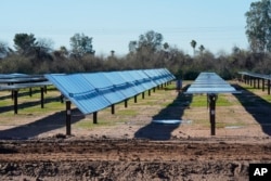Rows of solar panels sit at Orsted's Eleven Mile Solar Center lithium-ion battery storage energy facility Thursday, Feb. 29, 2024, in Coolidge, Ariz. (AP Photo/Ross D. Franklin)
