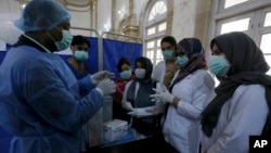 FILE - Paramedic staff attend a training session at a center newly setup for upcoming COVID-19 vaccination, in Karachi, Pakistan, Saturday, Jan. 30, 2021. Pakistan officials have set up centers in all districts of the country to administer COVID19 vaccines, which will start soon.