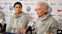 FILE - United States women's national soccer team member Alex Morgan, left, listens as teammate Megan Rapinoe speak to reporters during a news conference in New York, Friday, May 24, 2019.