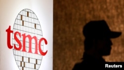 资料照：2014年7月16日，在台北的一次投资会议期间一名保安站在台积电标识旁。（路透社照片）