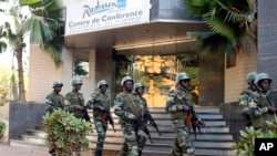 Des soldats de la garde présidentielle patrouillent devant l'hôtel Radisson Blu à Bamako, au Mali, le 21 novembre 2015.