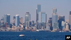 Kayakers and boaters ply the waters of Elliott Bay with the Seattle skyline behind during a heat wave hitting the Pacific Northwest, Sunday, June 27, 2021. (AP Photo/John Froschauer)