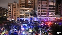 Люди собрались на месте удара по офису ХАМАС в южном пригороде Бейрута, 2 января 2024 года.