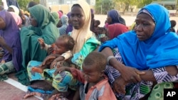 Des femmes et des enfants retenus captifs par des extrémistes islamistes et secourus par l'armée nigériane sont vus à leur arrivée à Maiduguri, au Nigeria, le lundi 20 mai 2024.
