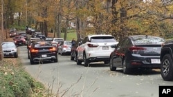Cars line a narrow road outside a private property in an undated photo, in Pomfret, Vt., that has become a destination for fall foliage viewers, clogging the rural road. (AP Photo)