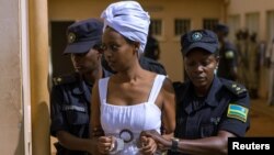 Diane Shima Rwigara escortée par des policières dans une salle d'audience à Kigali, au Rwanda, le 11 octobre 2017.
