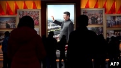 资料图：在北京的中国共产党历史展览馆，参观者从习近平的图片前走过（2021年11月11日）