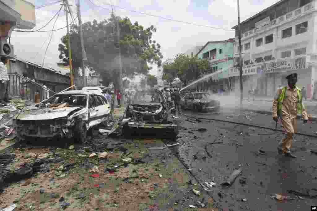 Un soldat somalien patrouille près des voitures détruites après l&#39;attentat près d&#39;un centre commercial à Mogadiscio, en Somalie, le 30 juillet 2017.