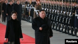 Le dirigeant nord-coréen Kim Jong Un et son épouse Ri Sol Ju passent en revue une garde d'honneur avant de quitter Pyongyang pour une visite en Chine. Photo publiée le 8 janvier 2019 par l'Agence centrale de presse nord-coréenne (KCNA) à Pyongyang via REUTERS 