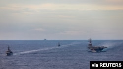 Les navires d'entraînement de la Force d'autodéfense maritime japonaise JS Kashima et JS Shimayuki effectuent un exercice de passage (PASSEX) avec le porte-avions à propulsion nucléaire de classe Nimitz USS Ronald Reagan dans la mer de Chine méridionale, le 7 juillet 2020.
