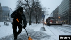 Un homme déneige le trottoir à Washington, le 22 janvier 2016. (REUTERS/Jonathan Ernst)