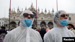 Des touristes portent des masques de protection à Venise en Italie le 23 février 2020.