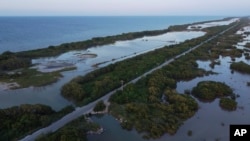 A highway cuts through a mangrove forest near the Dzilam de Bravo Reserve, in Mexico’s Yucatan Peninsula, Saturday, Oct. 9, 2021. (AP Photo/Eduardo Verdugo)