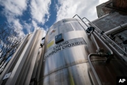 FILE - A liquid carbon dioxide containment unit stands outside the fabrication building of Glenwood Mason Supply Company, April 18, 2023, in the Brooklyn borough of New York. (AP Photo/John Minchillo, File)
