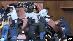 资料照片：国民党立法委员试图闯入台湾立法院时，民进党立委用椅子挡住入口。(2024年12月20日)