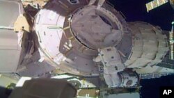 In this image made from video provided by NASA, U.S. astronauts Peggy Whitson, above, and Shane Kimbrough work on the outside of the International Space Station on Thursday, March 30, 2017. (NASA via AP)