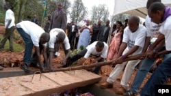 Des volontaires déposent dans caveau les restes des victimes du génocide de 1994, à Murambi, est du Rwanda, 07 avril 2005. epa / RICKY GARE