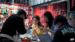 China Singles Day2024 年 11 月 8 日星期五，商家在位于中国东部浙江省义乌市的义乌批发市场内的商店里拍摄珠宝产品以供电子商务销售。