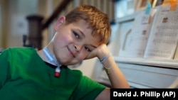 Braden Scott smiles after practicing on the piano in Tomball, Texas on Friday, March 29, 2019. Braden was diagnosed with the mysterious syndrome called acute flaccid myelitis, or AFM, in 2016 and was paralyzed almost completely.