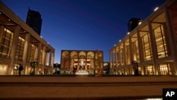 Театр Девіда Коха, ліворуч, і Ейвері Фішер Хол, праворуч, поруч із будівлею Метрополітен опери 13 листопада 2013 р. у Лінкольн центрі в Нью-Йорку. (Фото AP Photo/Kathy Willens, File)