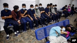 In this March 30, 2021 photo, young unaccompanied migrants wait for their turn at the secondary processing station inside a U.S. Customs and Border Protection facility in Texas. (AP Photo/Dario Lopez-Mills, Pool, File)