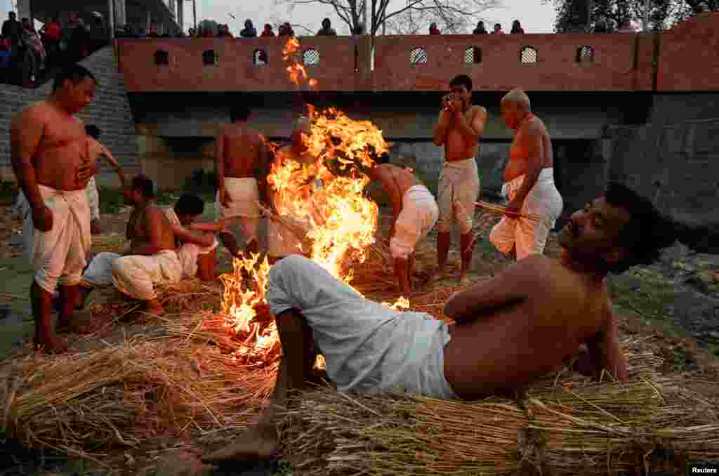 Devotees gather beside a fire before taking a holy bath at the Hanumante River during the final day of the month-long Swasthani Brata Katha festival in Bhaktapur, Nepal. REUTERS/Navesh Chitrakar