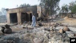 Un homme marche devant des maisons détruites par le groupe de Boko Haram à Dalori, près de Maiduguri, Nigeria, le 31 janvier 2016.