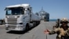 Trucks carry humanitarian aid across Trident Pier