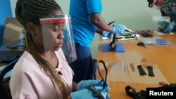 Préparation des écrans faciaux à partir de plastiques recyclés à Dar es Salaam, en Tanzanie, le 27 mai 2020. (Photo Reuters)