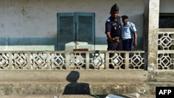 Un officier de police des Comores prend en photo avec son téléphone une urne détruite au bureau de vote de Hankounou, où le matériel de vote a été vandalisé à l'ouverture du vote, le 30 juillet 2018.
