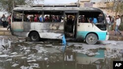 Quelques badauds s’assemblent après une explosion de voiture piégée sur un marché en plein air bondé dans la zone irakienne de Sadr City, Irak, 2 janvier 2017.